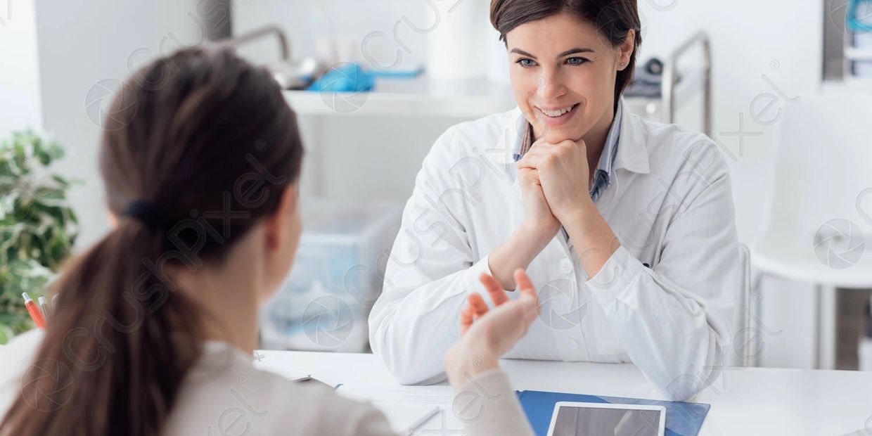 A female doctor attentively listens to a patient during a consultation.