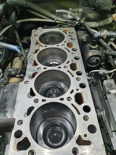 Close-up of a car engine block with exposed cylinders.