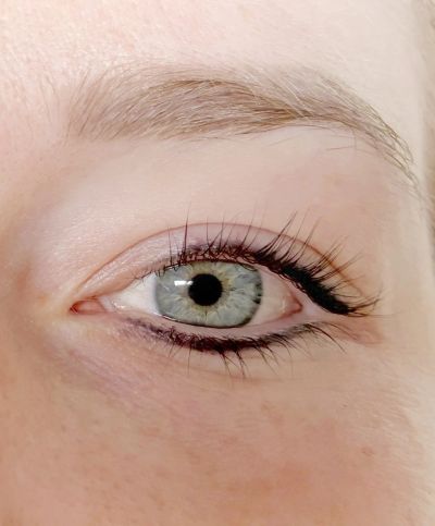 Close-up van een blauwachtig oog met lange wimpers.