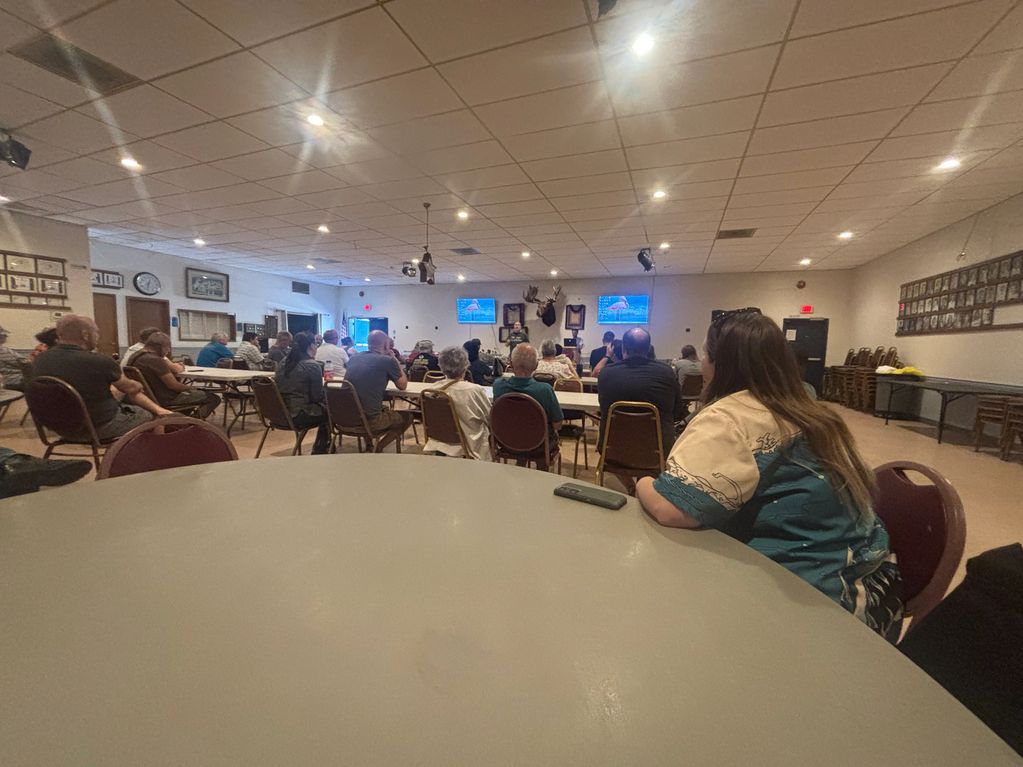 People gathered in a hall for a presentation or meeting.