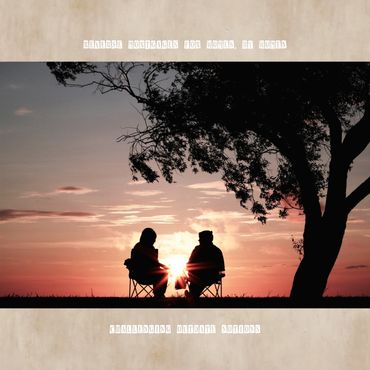 Two women sit under a tree at sunset, symbolizing empowerment and support.
