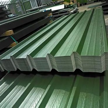 Stack of green corrugated metal roofing sheets in a warehouse.