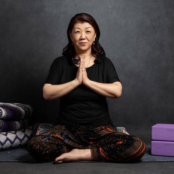 Woman meditating in a seated yoga pose with hands in prayer position.