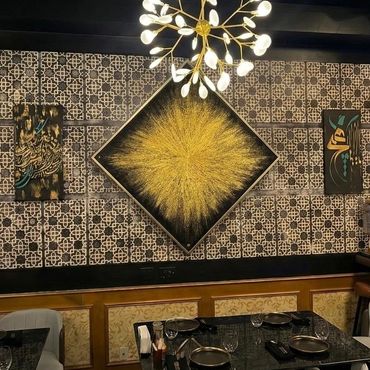 Elegant dining area with golden abstract art and intricate patterned walls.