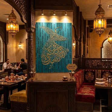 Warmly lit Middle Eastern restaurant interior with intricate decor and traditional seating.