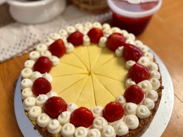 Cheesecake topped with fresh strawberries displayed on a table.