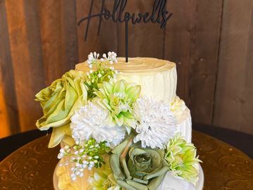 2-tier wedding displayed on gold ornamental plate and rustic table.