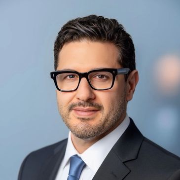 Professional man in suit and glasses with a confident expression.