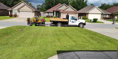 Freshly mowed yard with Premier Coast Landscaping truck out front