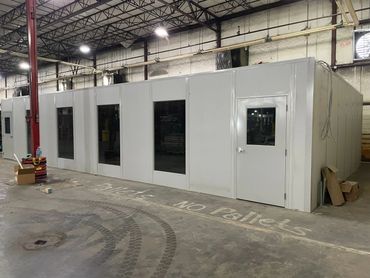 A new grey modular office building with large windows, door. Inside a warehouse by SoFlo installati