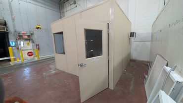 A small beige Modular Office installed inside a warehouse setting by SoFlo Installations