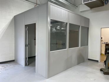 A new modular office building configuration of two walls in a corner, with several windows, door.