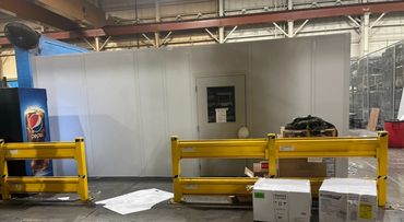 A prefab Modular break room inside yellow railings installed in a warehouse setting