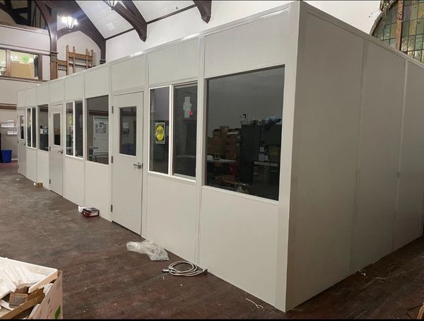 Modular offices with windows and doors, constructed by SoFlo Installations, set up within a larger b