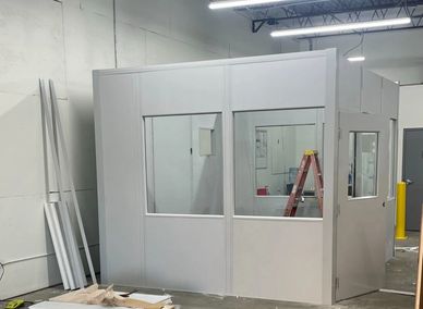 Modular office solutions with large windows, under construction in an industrial setting. By SoFlo