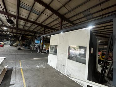 A prefab Modular Office with several windows installed inside an industrial setting