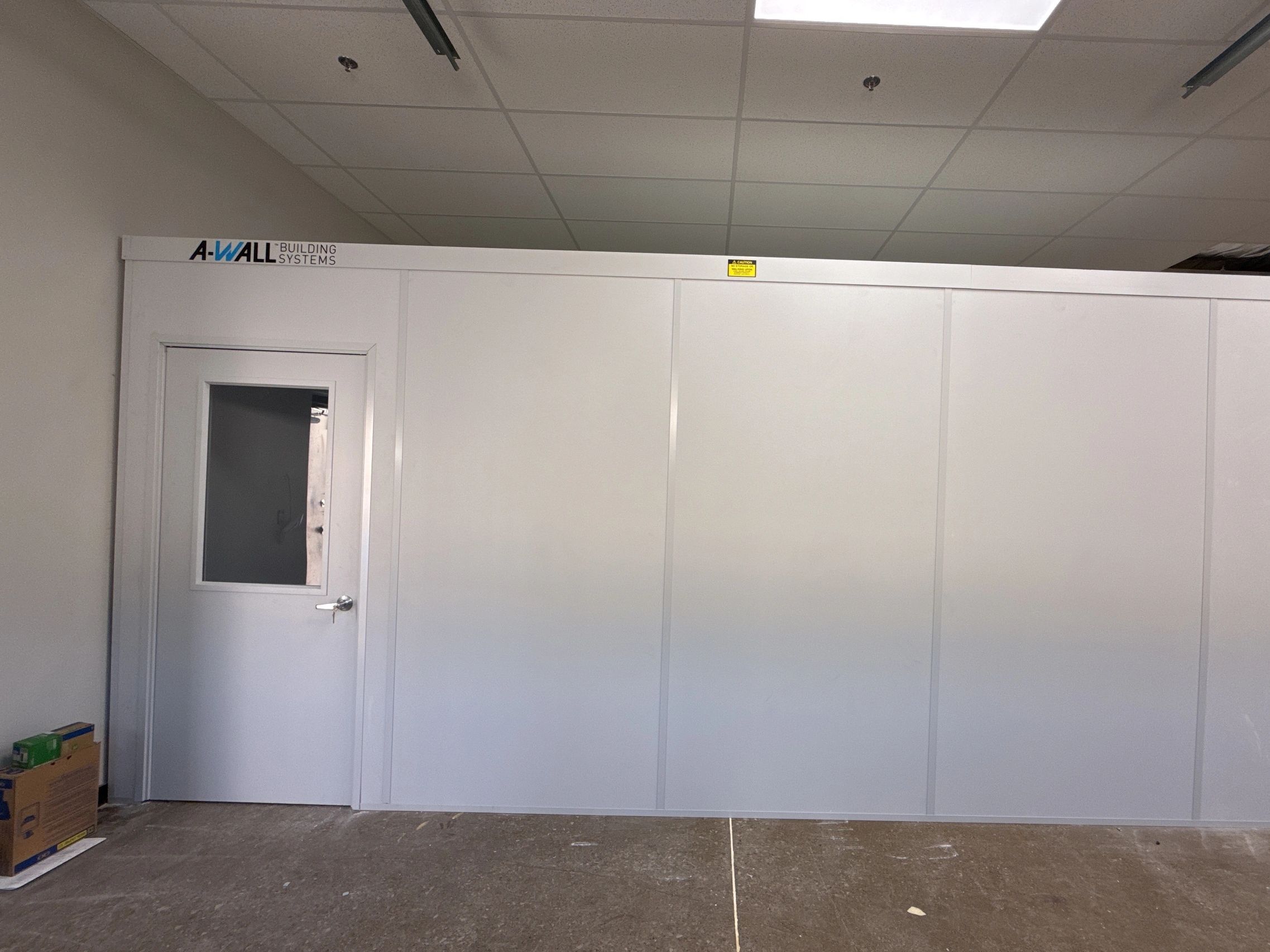 A white modular office building installed inside a an office workspace by SoFlo Installations
