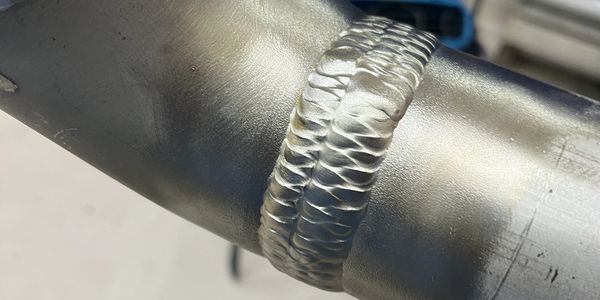 Close-up of a polished metal weld on a pipe.
