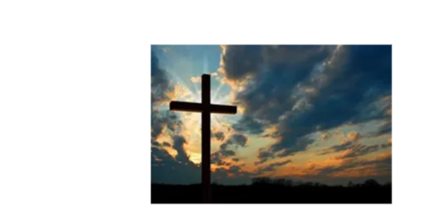 Silhouette of a cross against a colorful sunset sky.