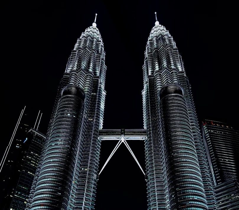 Illuminated twin towers against a dark night sky.