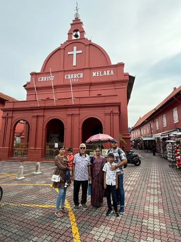 Family posing in front of the historic Christ Church Melaka in Malaysia.