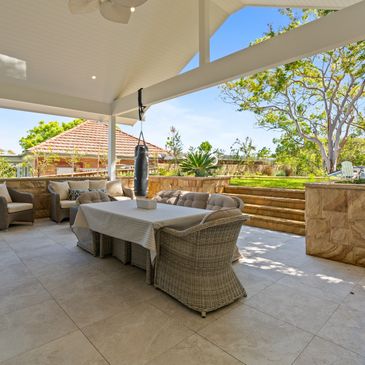 Outdoor entertaining area with sandstone retaining walls and high ceilings