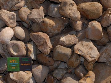 River Rock or Bull Rock with Coastal Landscape Supplies business card in the corner.