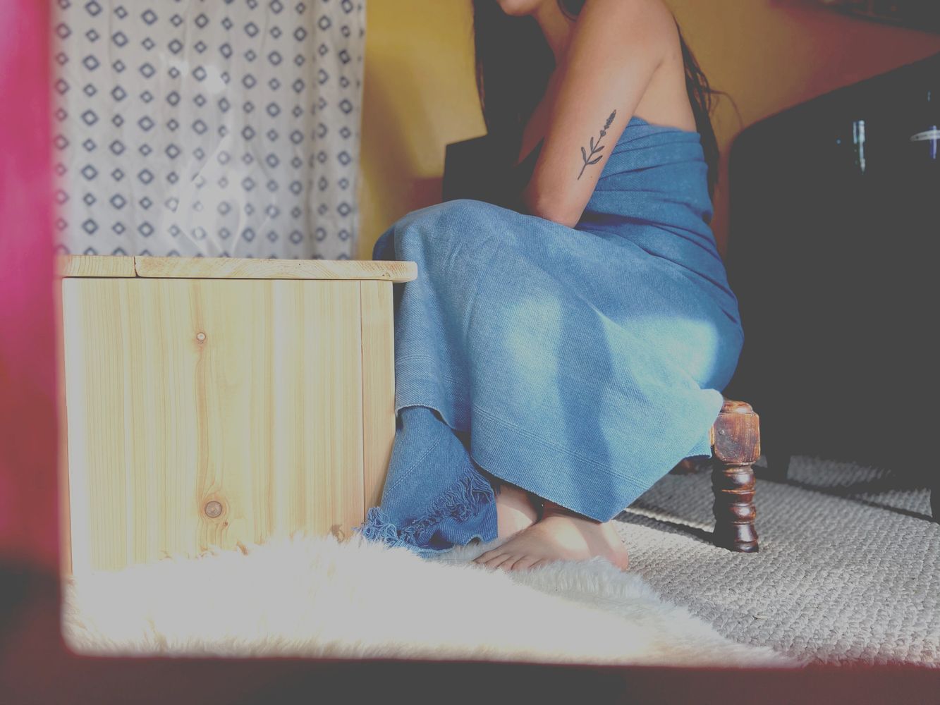 Image of Julia wrapped in a blue linen towel sitting next to her steam seat. Steam is rising from th