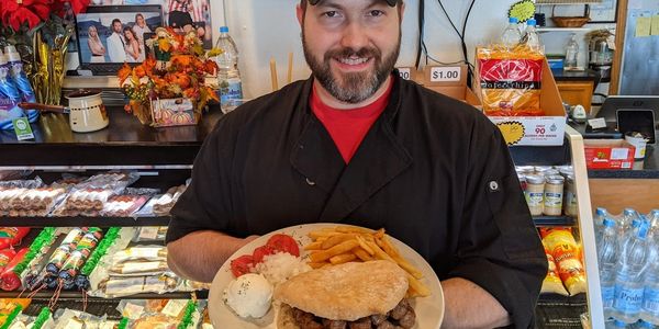 A man holding a sandwich meal on a plate