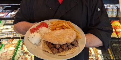 A man holding a plate of full meal