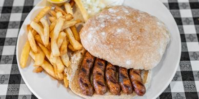 A plate of fries and a sausage sandwich