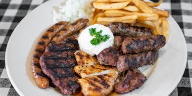 A plate full of meat, sausages and fries