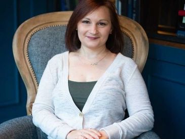 Lindsay Hayes, relationship therapist, sitting in a wingback chair, facing the camera