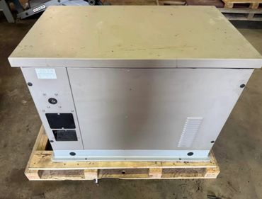 Large industrial generator on a wooden pallet in a warehouse.