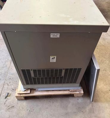 A weatherproof electrical enclosure on a wooden pallet with a vented panel.