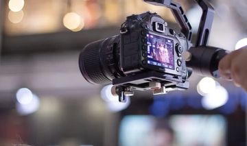 Professional DSLR camera on stabilizer capturing footage.