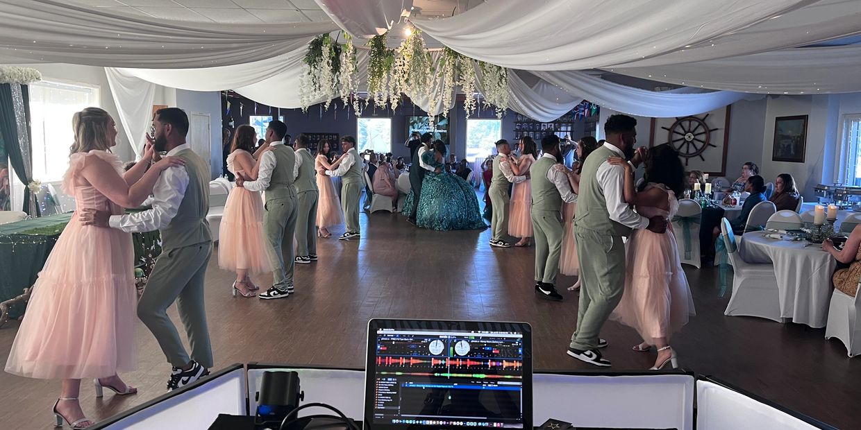 Couples in formal attire dancing at a decorated wedding reception.