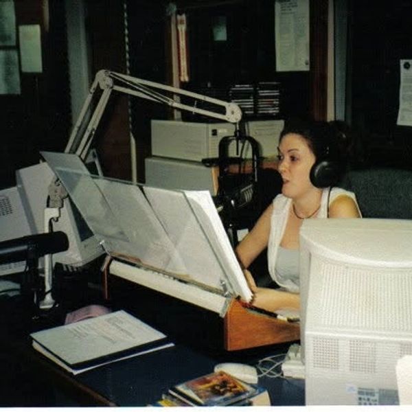Woman speaking into a microphone in a radio studio.