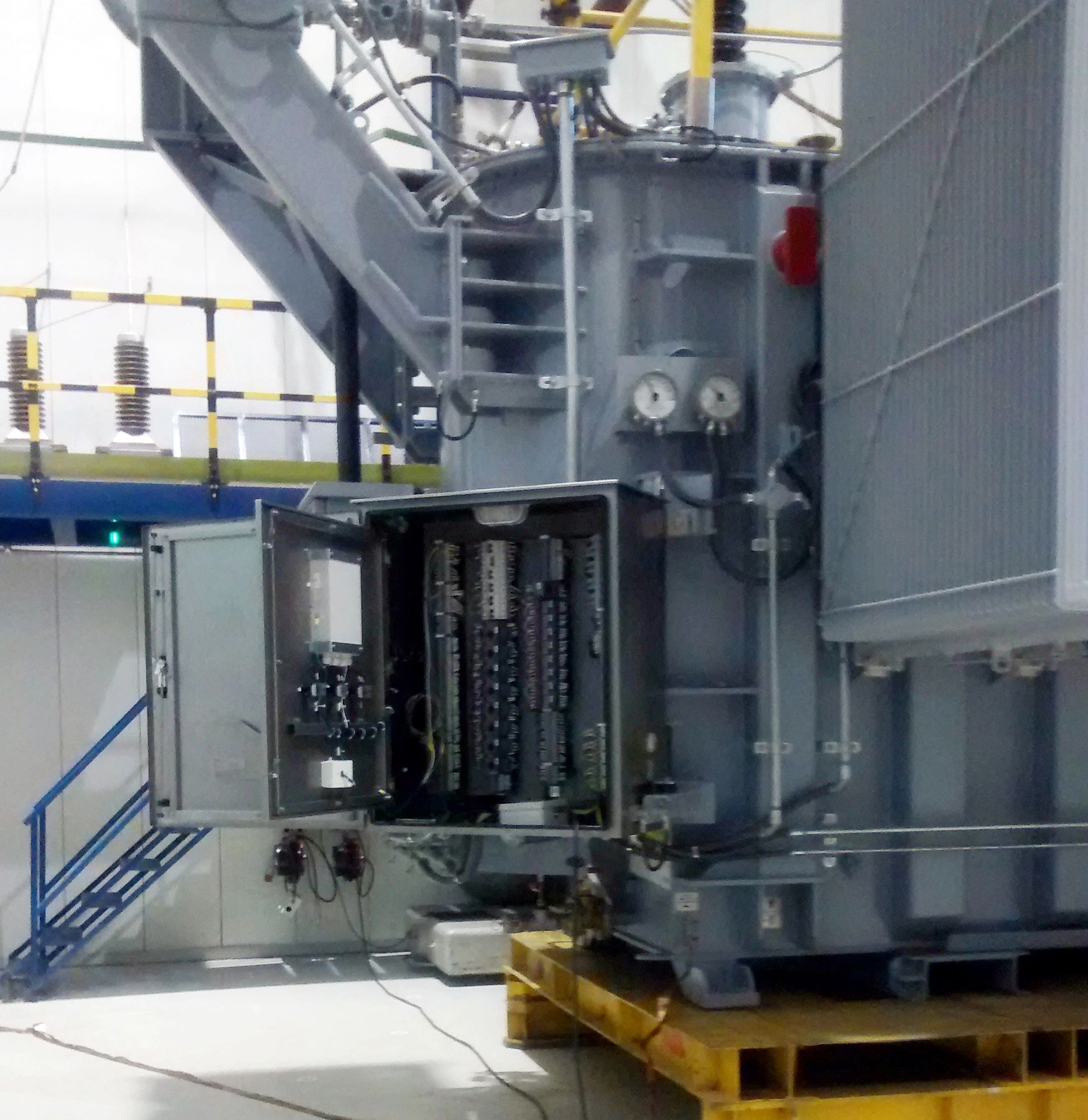 Equipamiento eléctrico industrial abierto en un entorno de fábrica.