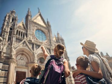 Family exploring cathedral in Italy, pointing out architecture and history on a Europe vacation