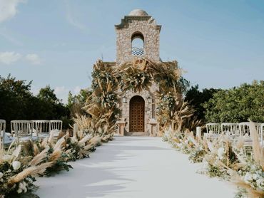 Modern boho outdoor chapel styled with pampas and florals for a nature-inspired wedding ceremony.