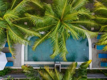 Top-down view of Hawaii resort pool surrounded by palm trees, tropical relaxation at its best
