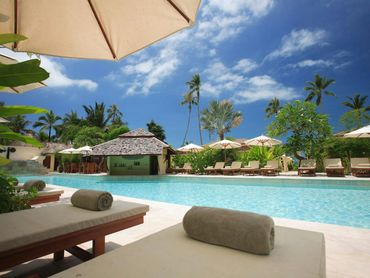 Poolside loungers at a quiet tropical resort in Riviera Maya, perfect for sun and serenity.
