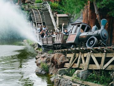 Log flume coaster plunges down a mountain in a wild west-style Disney-inspired theme park ride