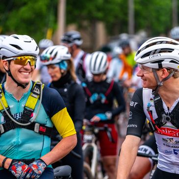 Cyclists smiling at each other during a ride.