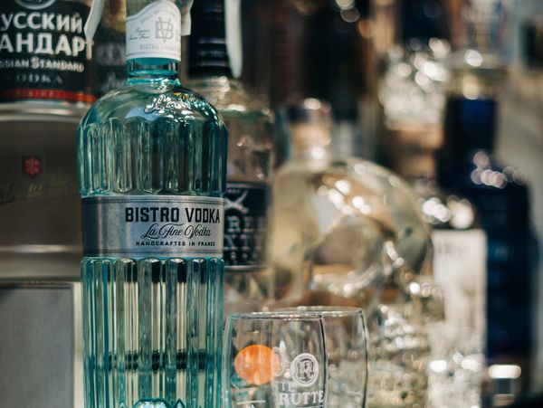 Assorted vodka bottles and glassware on a bar shelf. South Africa liquor license