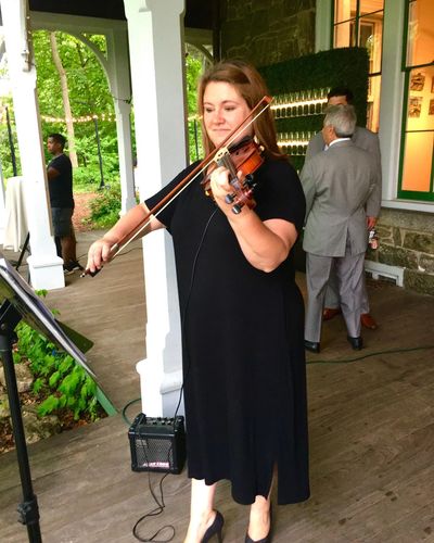Solo violinist performing for an outdoor wedding ceremony at Awbury Arboretum in Philadelphia Pennsy