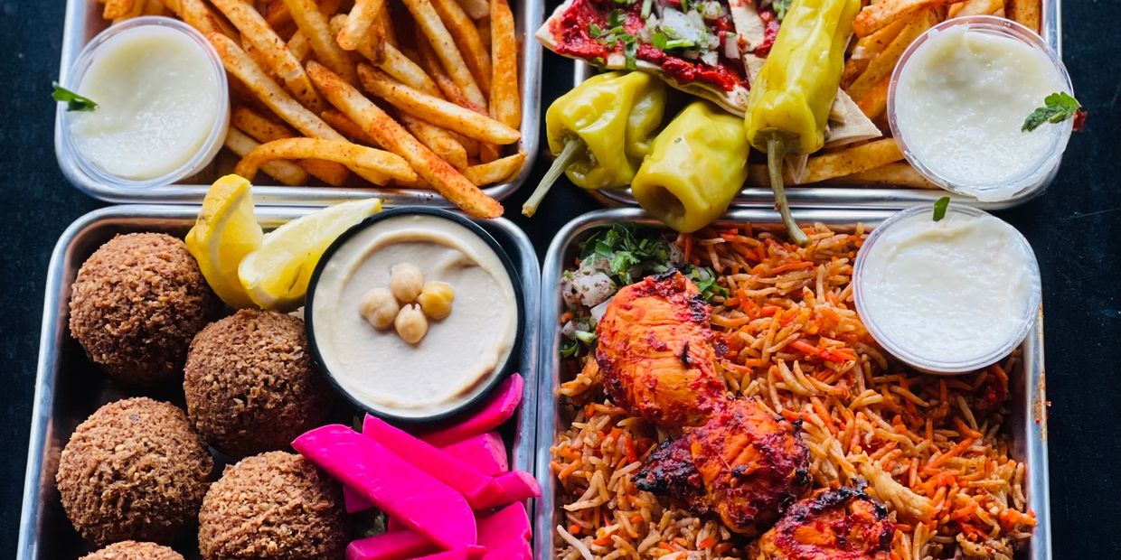 Variety of Middle Eastern dishes with fries, falafel, hummus, rice, and grilled chicken.