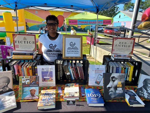 Founder, Tiffany Williams showing her books by African American authors - Sankofa Essential Books