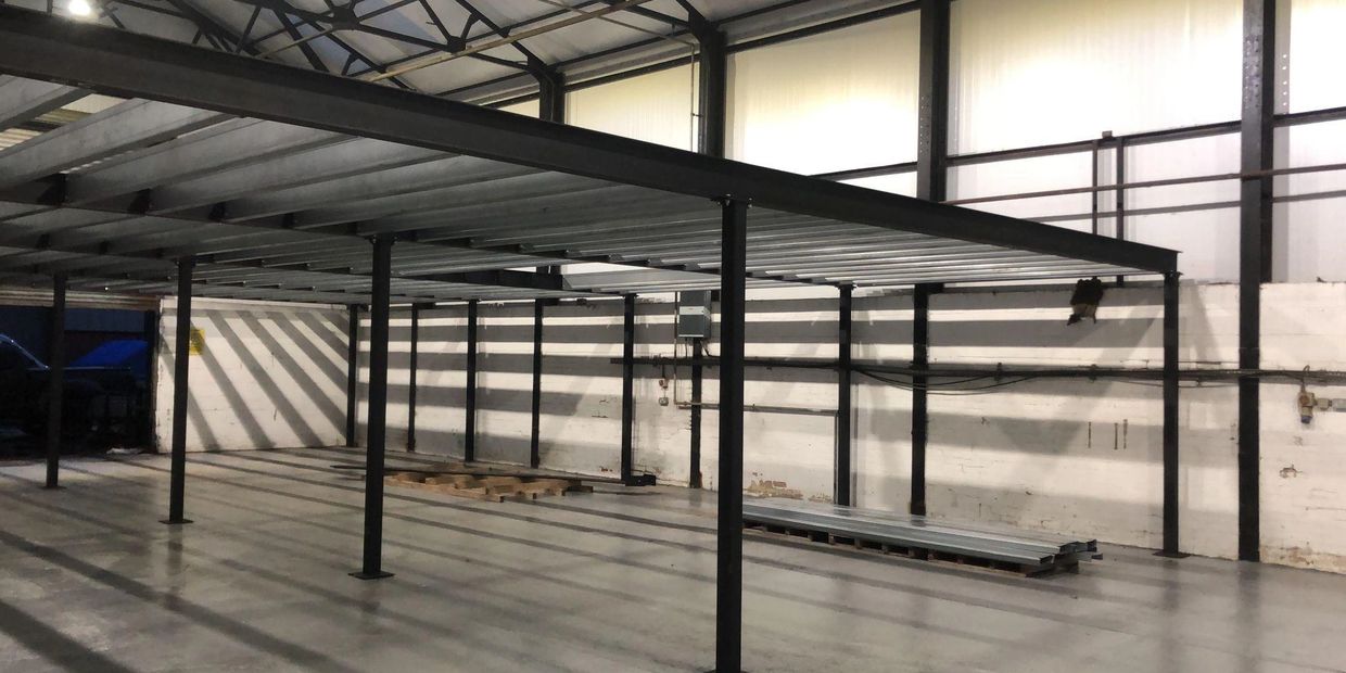 Interior of a warehouse with metal framework and pallets.